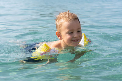 The child learns to swim. happy child swims in the sea. holidays in greece