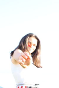 Young woman eating food against white background