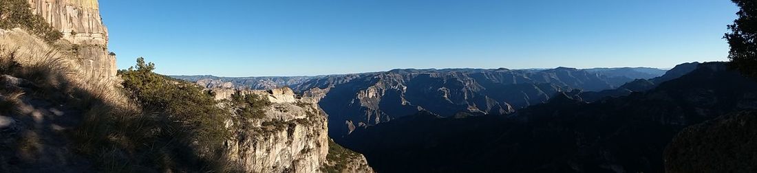 Panoramic view of mountains against clear blue sky