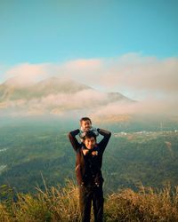 Portrait of man standing on mountain against sky