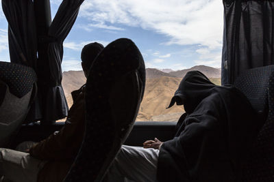 People sitting in bus against mountains