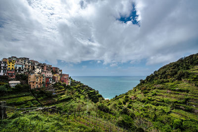 Scenic view of sea by buildings against sky