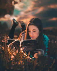 Portrait of young woman photographing in field