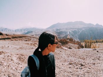 Young woman in desert against clear sky