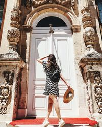 Woman standing at entrance of historic building
