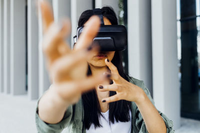 Woman wearing virtual reality simulator gesturing with hands