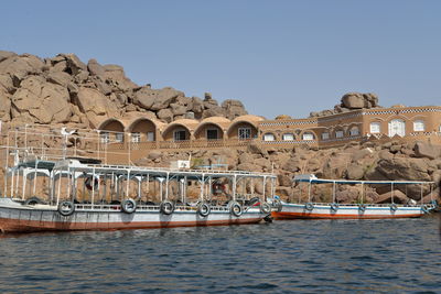 Built structure by river against clear sky