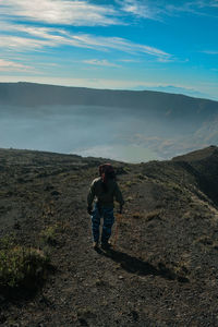 Rear view of man standing on mountain