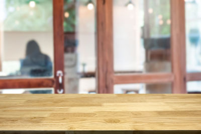 Rear view of man on table by window in building