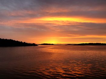 Scenic view of sea against dramatic sky during sunset