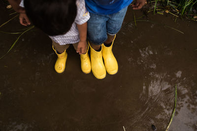 Low section of child standing on water during rainy season