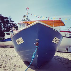 Ship moored in water against clear blue sky