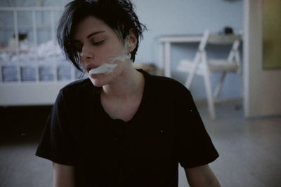 Portrait of young woman smoking  standing outdoors