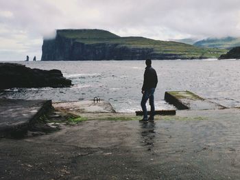 Tourists standing on rocks at beach