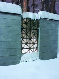 Snow covered building seen through window