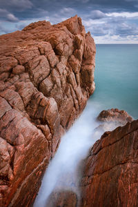 Rock formations in sea against sky