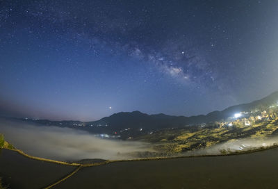 Scenic view of illuminated mountains against sky at night