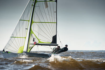 Sailboat sailing on sea against clear sky