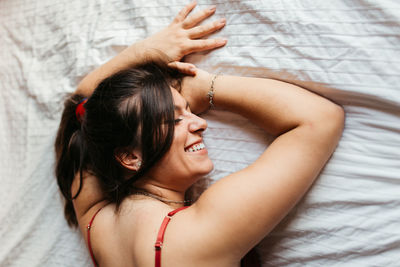 Midsection of woman lying on bed