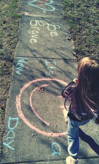 High angle view of girl playing hopscotch outdoors