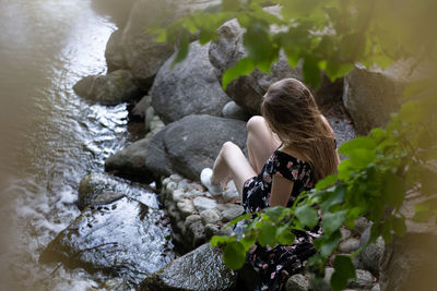 High angle view of woman sitting on rock