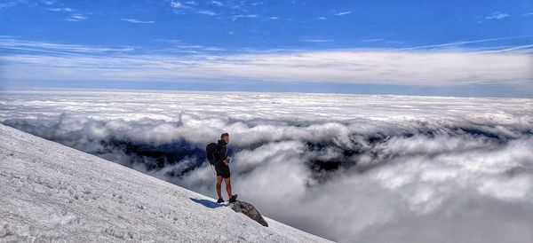 Man on snowcapped mountain against sky