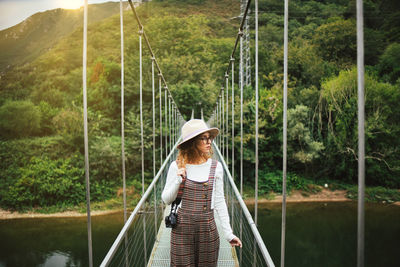 Rear view of woman standing on footbridge