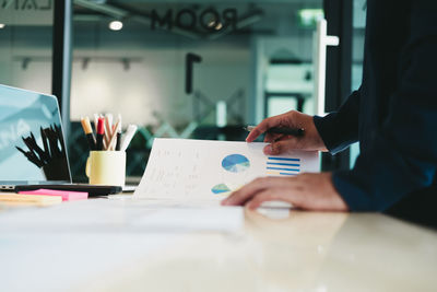 Midsection of woman working at table