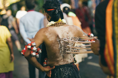 Rear view of people holding cross against blurred background