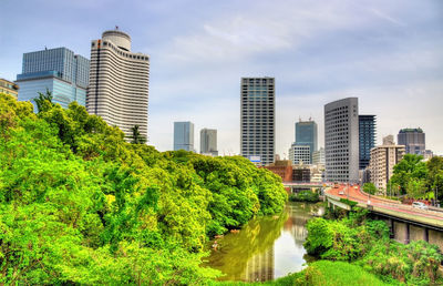 Canal amidst buildings in city against sky