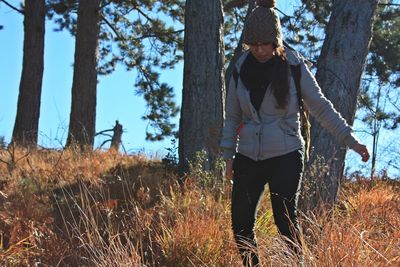 Woman standing on mountain against trees