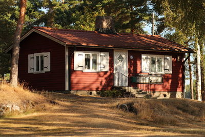 Exterior of abandoned house on field against trees