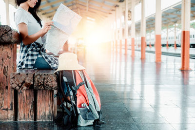Woman sitting on chair against building