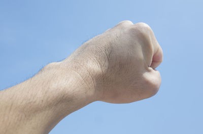 Close-up of hand against clear blue sky