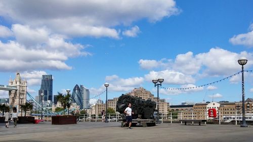 Man jogging on footpath against cloudy sky