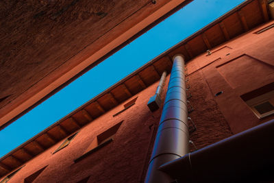 Low angle view of water pipe on building against sky