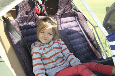 Portrait of smiling girl sitting in air vehicle