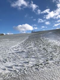 Tire tracks on sand against sky