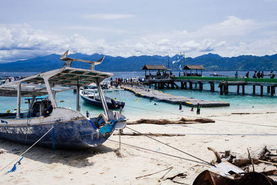 Boats moored on shore against sky