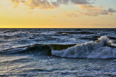 Scenic view of sea wave against sky during sunset