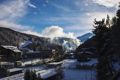 Houses amidst mountains against sky during winter