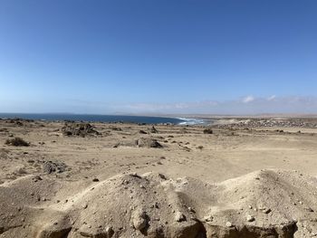 Scenic view of beach against clear blue sky