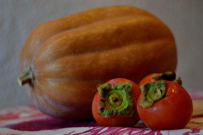 Close-up of pumpkin and persimmon on table