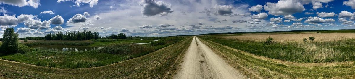 Panoramic shot of road amidst land against sky