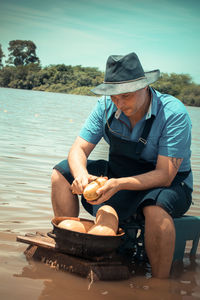 Man wearing hat sitting in water