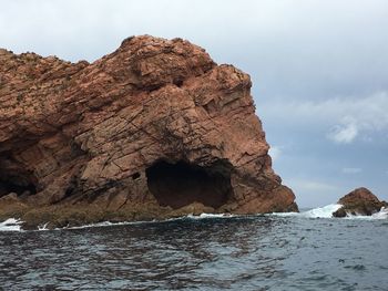 Rock formations by sea against sky