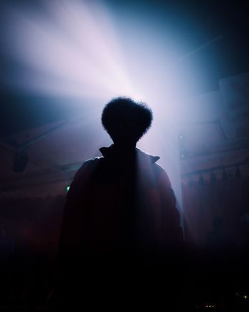 REAR VIEW OF SILHOUETTE MAN STANDING AGAINST SKY
