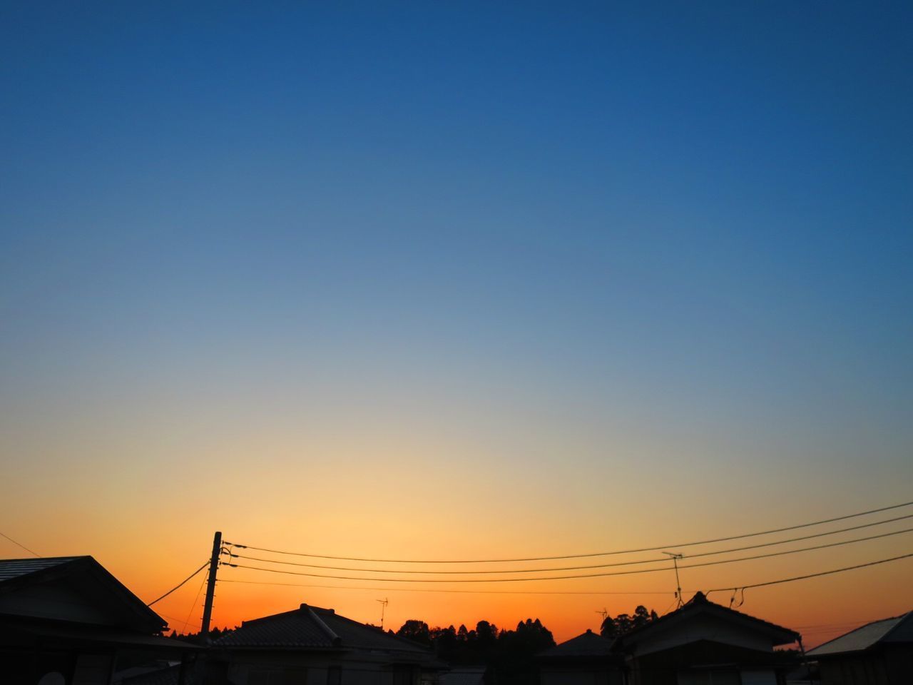 LOW ANGLE VIEW OF SILHOUETTE BUILDINGS AGAINST CLEAR BLUE SKY