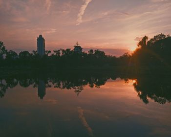 Reflection of trees in lake during sunset