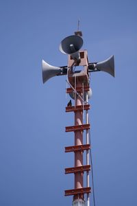 Low angle view of crane against clear blue sky